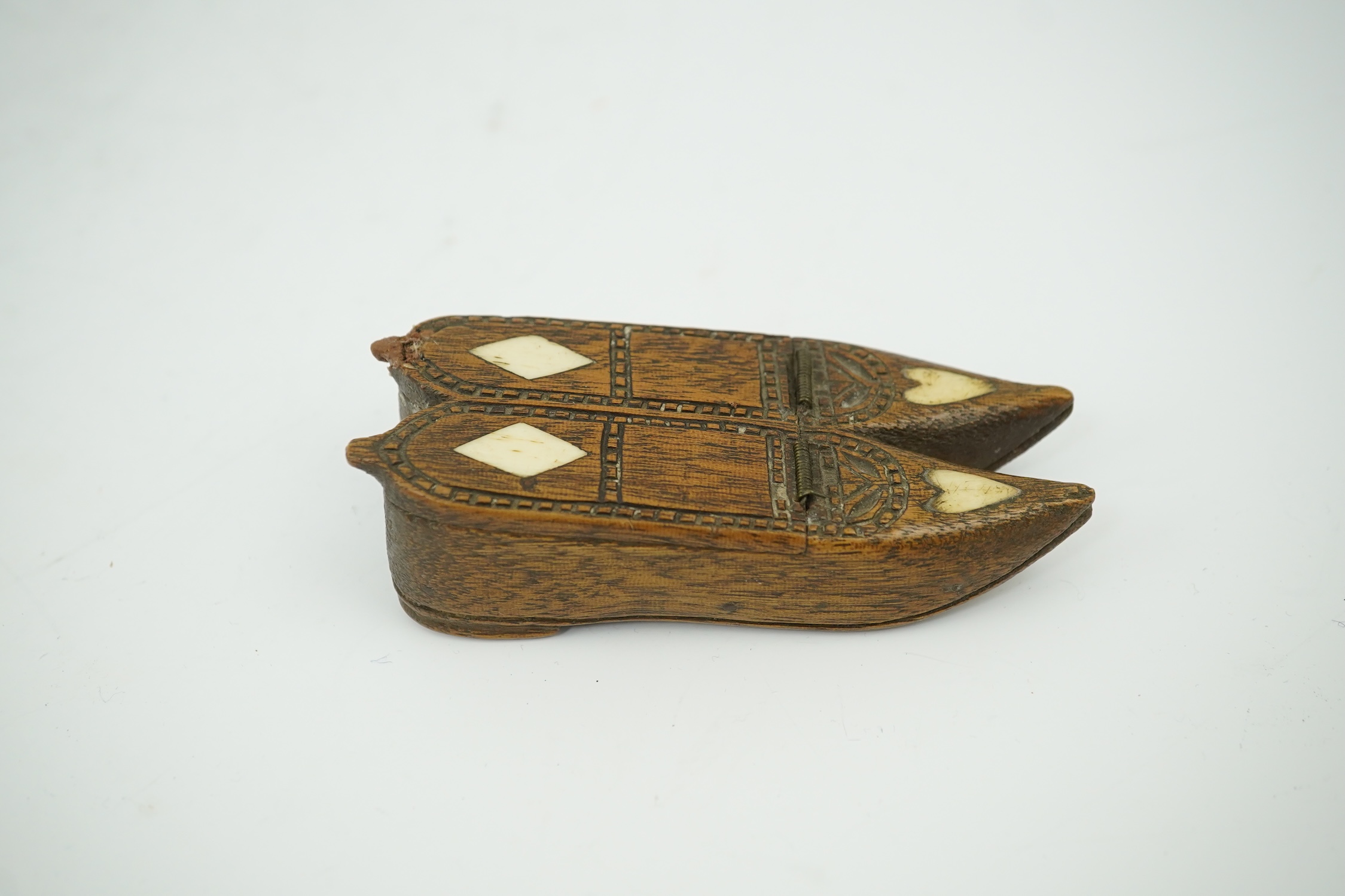 An early 19th century bone inset carved wood 'pair of shoes' snuff box with damaged sprung lid, 9.5cm long. Condition - good